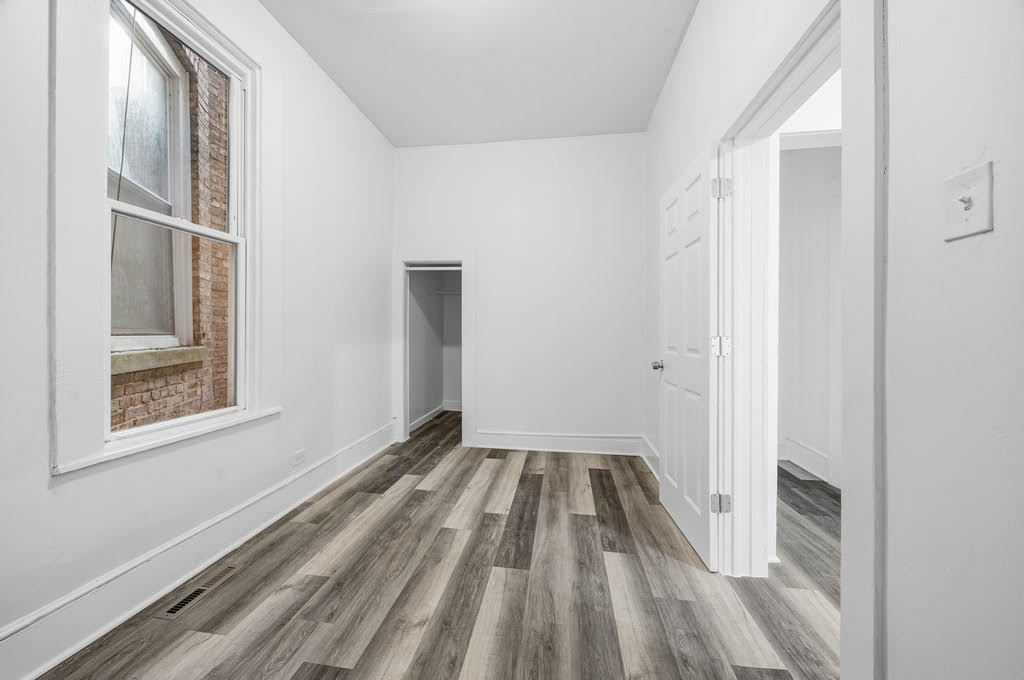 8919 South Exchange Avenue Chicago, IL 60617 - Photo 30 of 41 a view of an empty room with wooden floor and a window