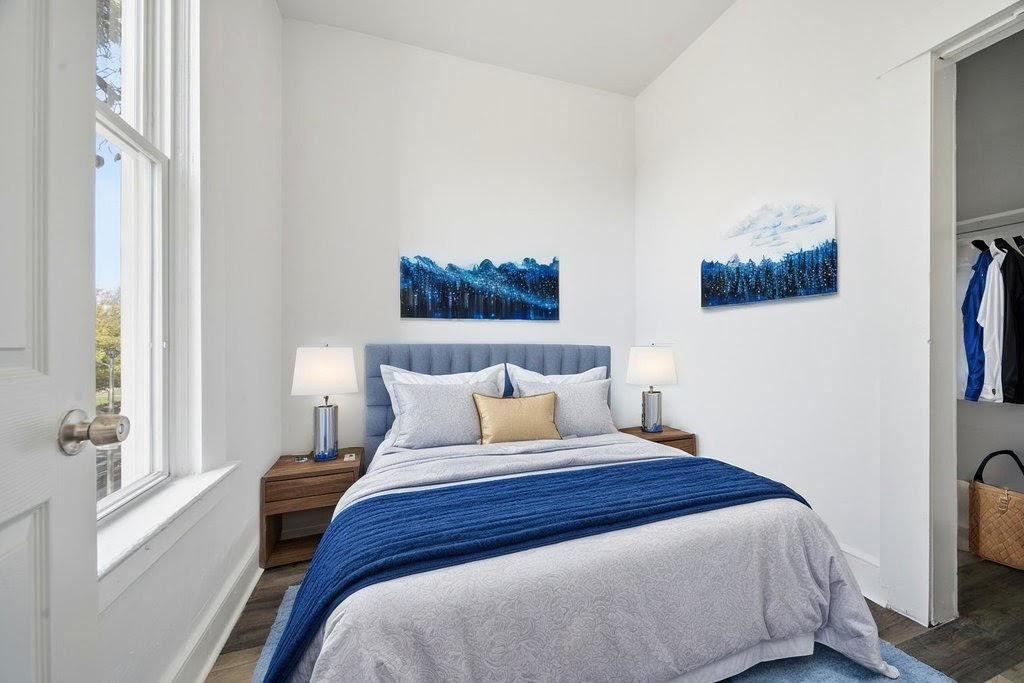 8919 South Exchange Avenue Chicago, IL 60617 - Photo 33 of 41 a bedroom with a bed a painting on the wall and a window