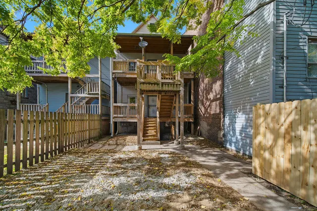 a view of a house with a small yard and wooden fence