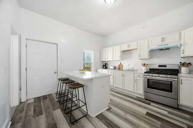 a kitchen with a sink cabinets stainless steel appliances and a window