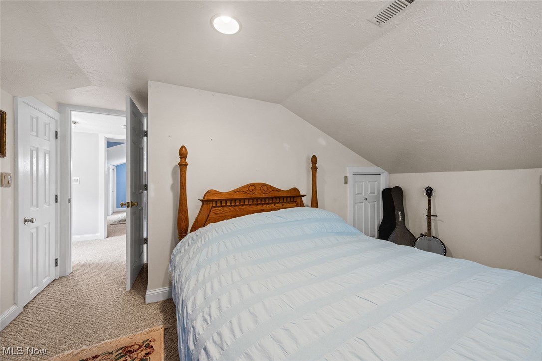3945 Columbia Road Medina, OH 44256 - Photo 24 of 40 Bedroom with a textured ceiling, lofted ceiling, and light carpet
