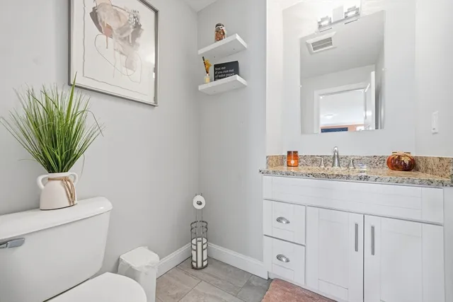 a bathroom with a granite countertop bathtub shower sink and toilet