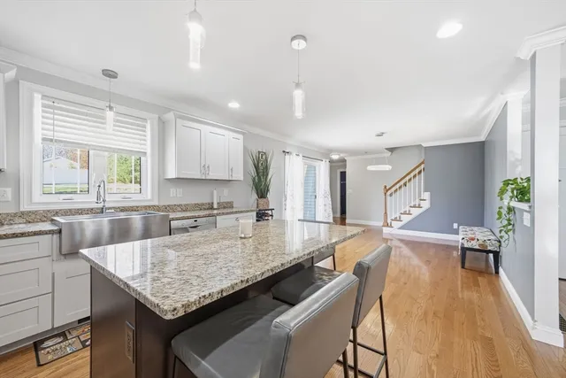 a kitchen with granite countertop kitchen island a table and chairs in it
