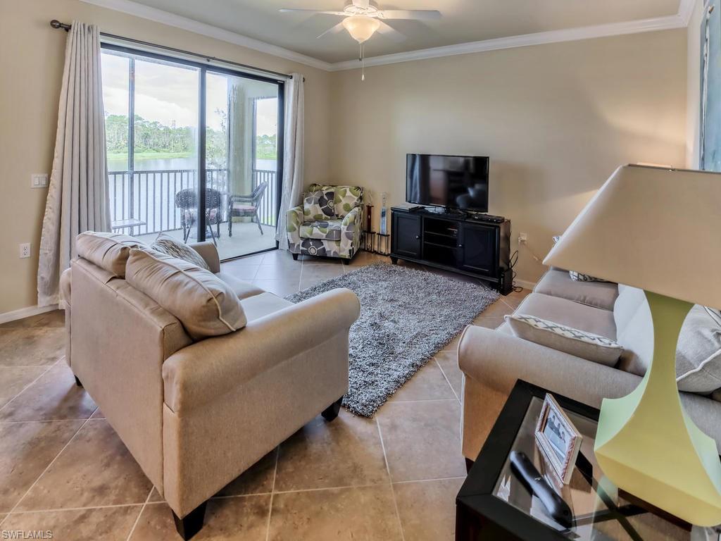 9727 Acqua Court, Unit 427 Naples, FL 34113 - Photo 22 of 29 a living room with furniture and a flat screen tv