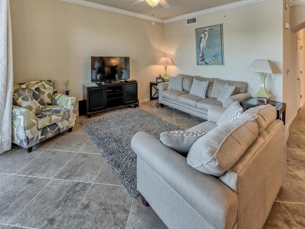 9727 Acqua Court, Unit 427 Naples, FL 34113 - Photo 23 of 29 a living room with furniture and a flat screen tv