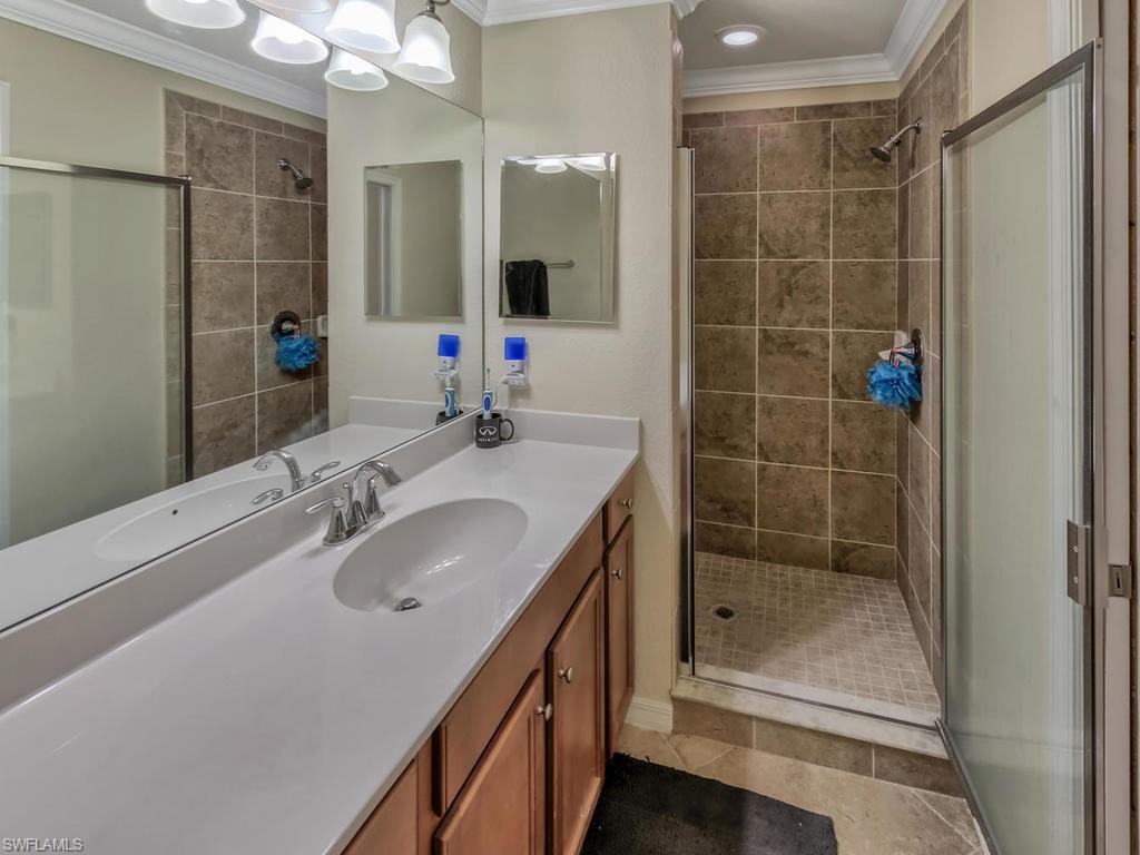 9727 Acqua Court, Unit 427 Naples, FL 34113 - Photo 26 of 29 a bathroom with a shower sink and mirror