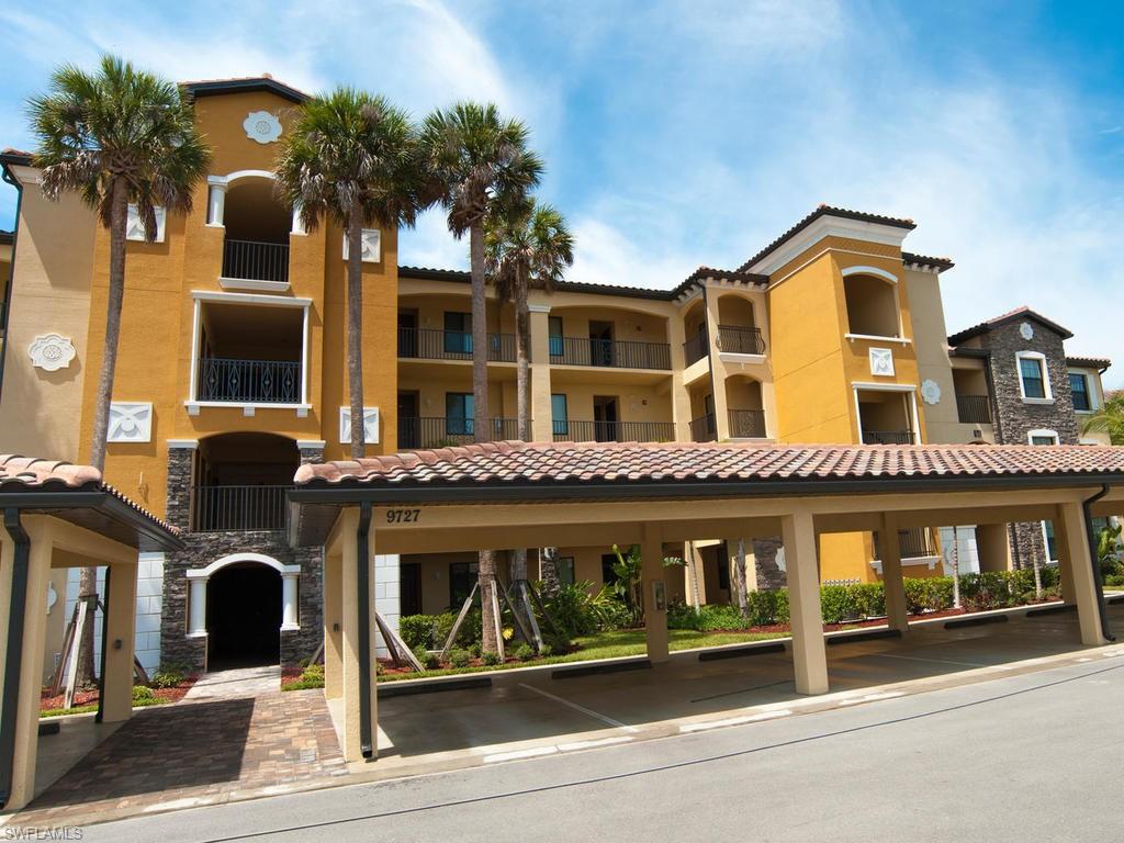 9727 Acqua Court, Unit 427 Naples, FL 34113 - Photo 4 of 29 a front view of a building with glass windows and a street
