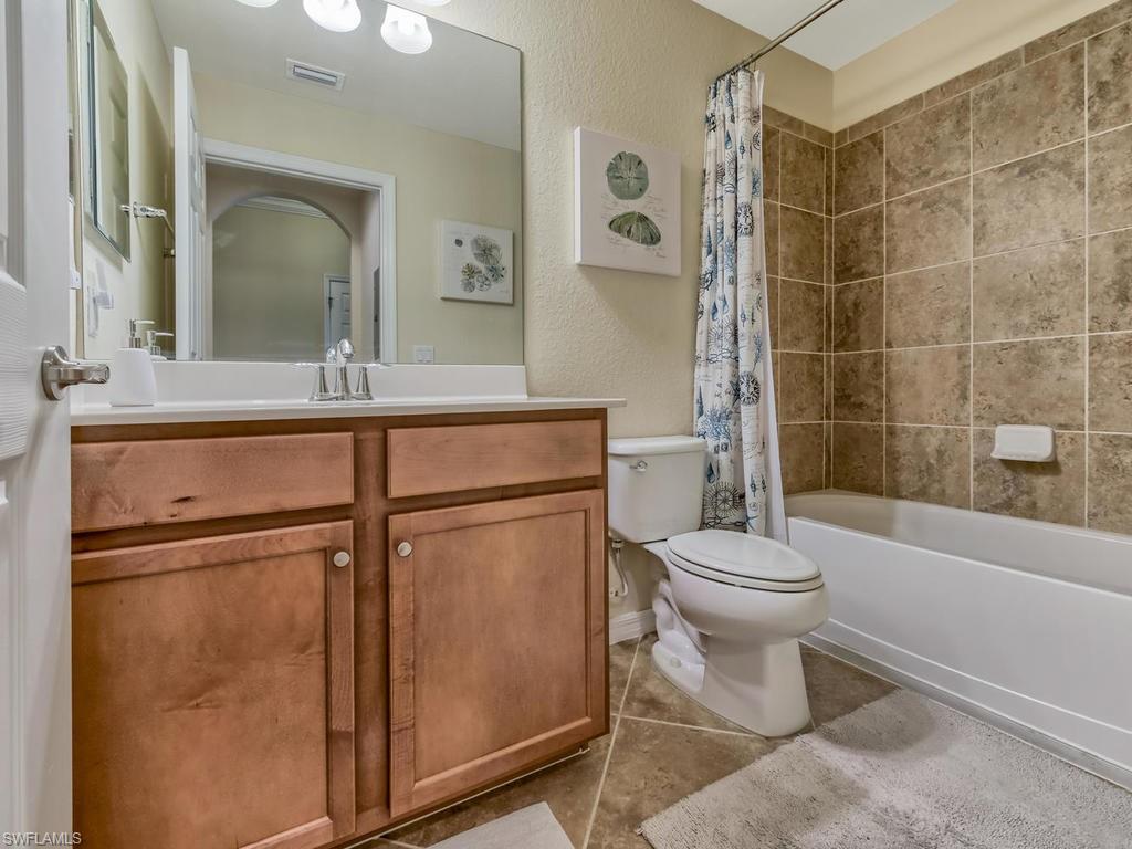 9727 Acqua Court, Unit 427 Naples, FL 34113 - Photo 8 of 29 a bathroom with a toilet a sink and shower