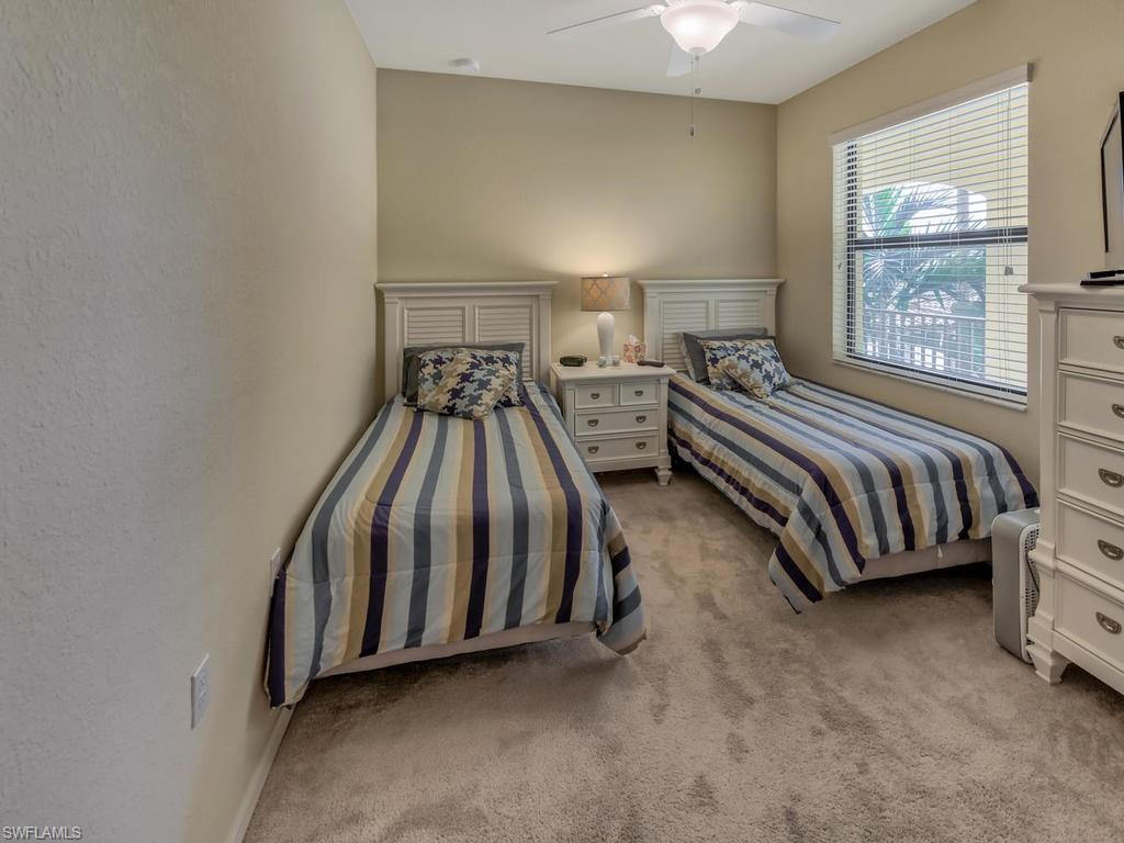 9727 Acqua Court, Unit 427 Naples, FL 34113 - Photo 9 of 29 a spacious bedroom with a bed and a window