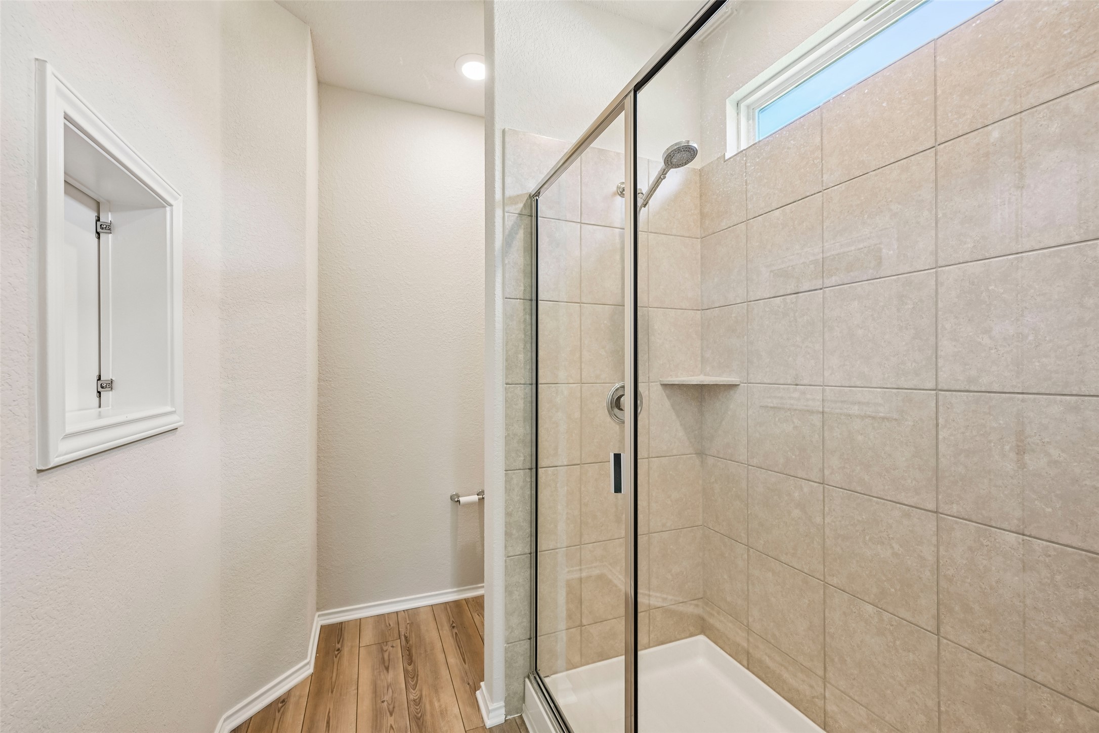 401 Yorktown Street Georgetown, TX 78633 - Photo 23 of 38 Shower enclosure featuring clear glass panels, a chrome showerhead, and a built-in tiled shelf