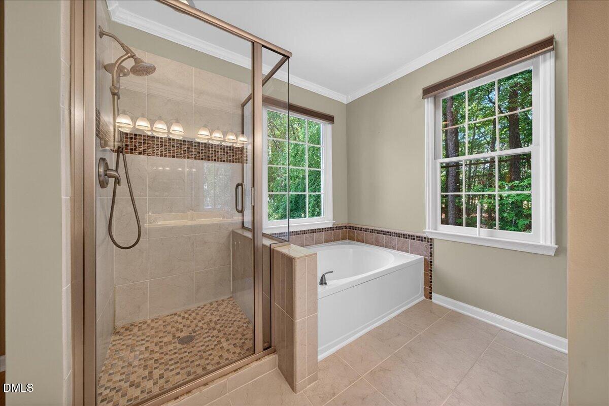 9536 Bells Valley Drive Raleigh, NC 27617 - Photo 26 of 39 a bathroom with a tub a mirror and a shower