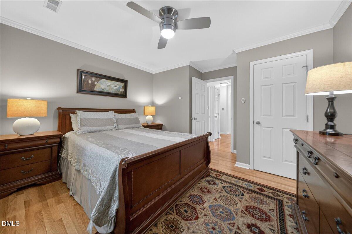 9536 Bells Valley Drive Raleigh, NC 27617 - Photo 31 of 39 a spacious bedroom with a bed and a lamp on dresser