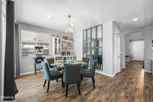 a large white kitchen with kitchen island a sink table and chairs