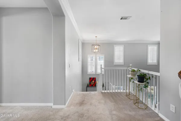 a front view of a house with a yard and potted plants