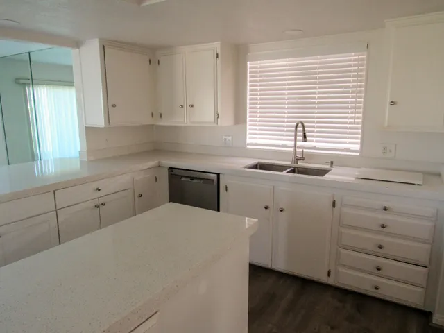 a kitchen with cabinets appliances and a window