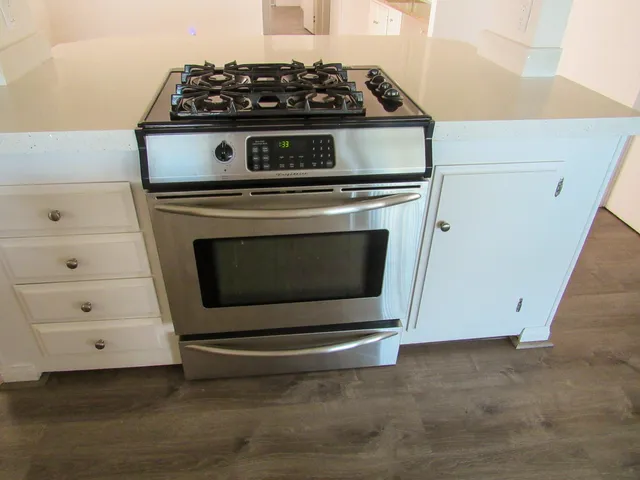 a stove top oven sitting inside of a kitchen