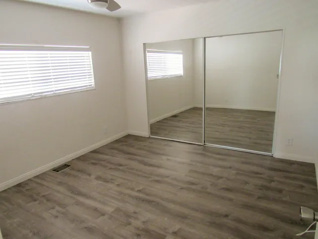 a view of a room with wooden floor and window