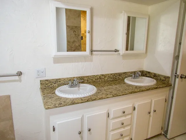 a bathroom with a granite countertop sink and a mirror