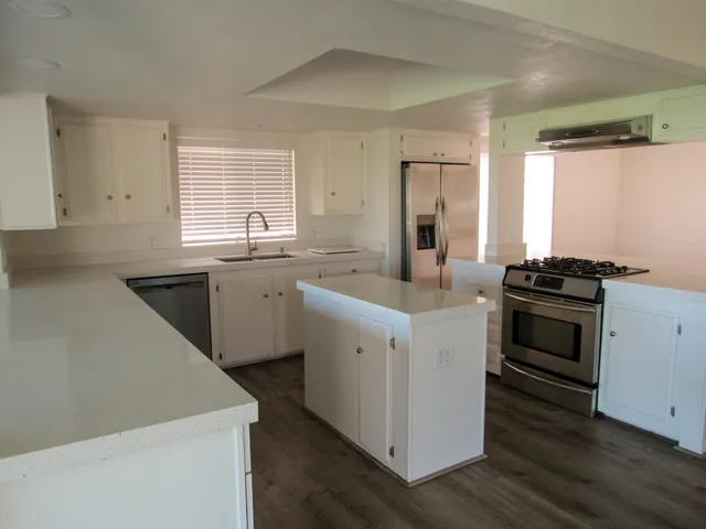 a kitchen with a sink stove top oven and refrigerator