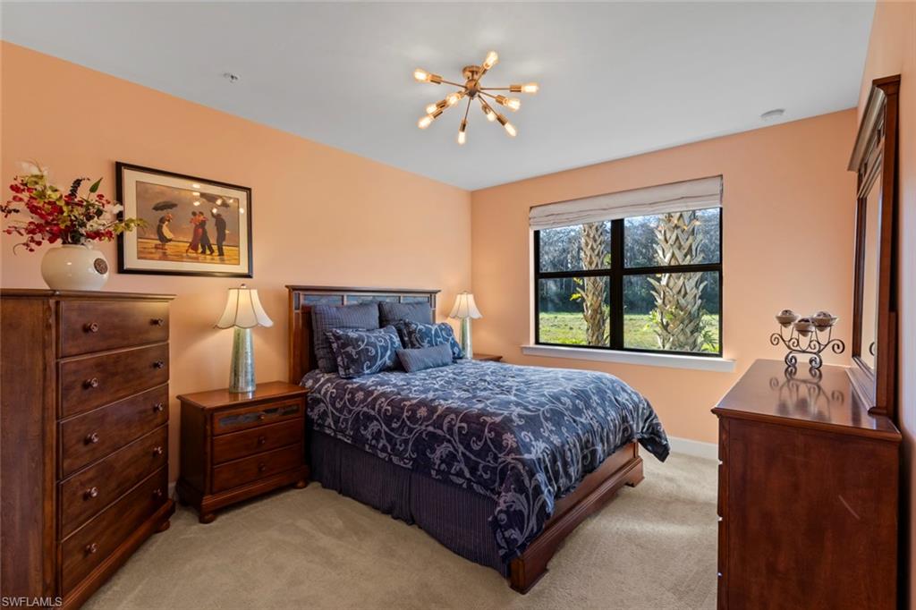 5701 Mayflower Way, Unit 1302 Ave Maria, FL 34142 - Photo 13 of 32 a bedroom with a bed and a dresser next to a window