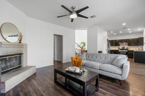 a living room with furniture a fireplace and a chandelier