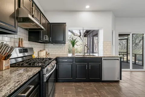 a kitchen with stainless steel appliances granite countertop a stove and a sink