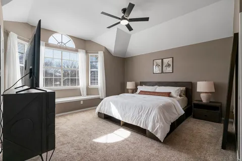 a bedroom with a bed and a large window