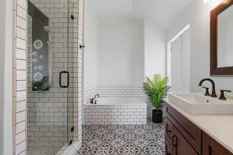 a bathroom with a sink a potted plant and a shower