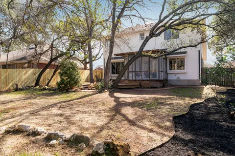 a view of a yard with wooden fence and a large tree