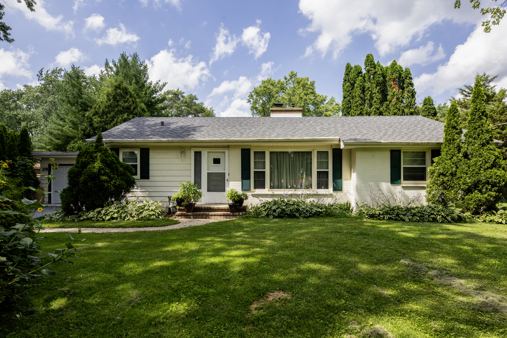 a front view of a house with a garden and porch