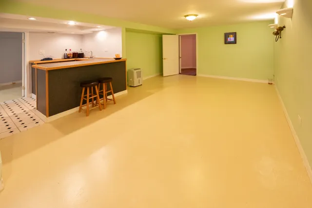 a view of kitchen and empty room with wooden floor