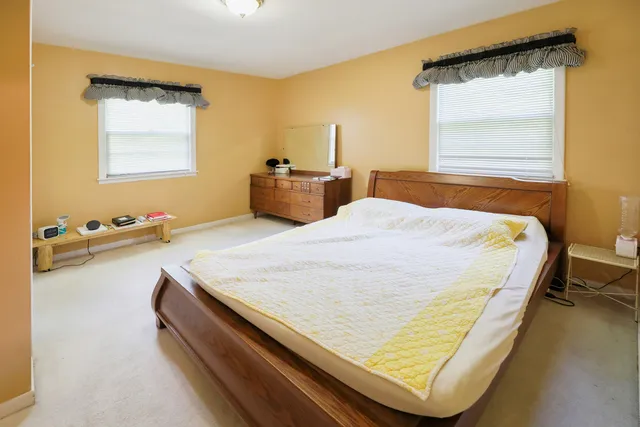 a bed sitting in a bedroom next to a window