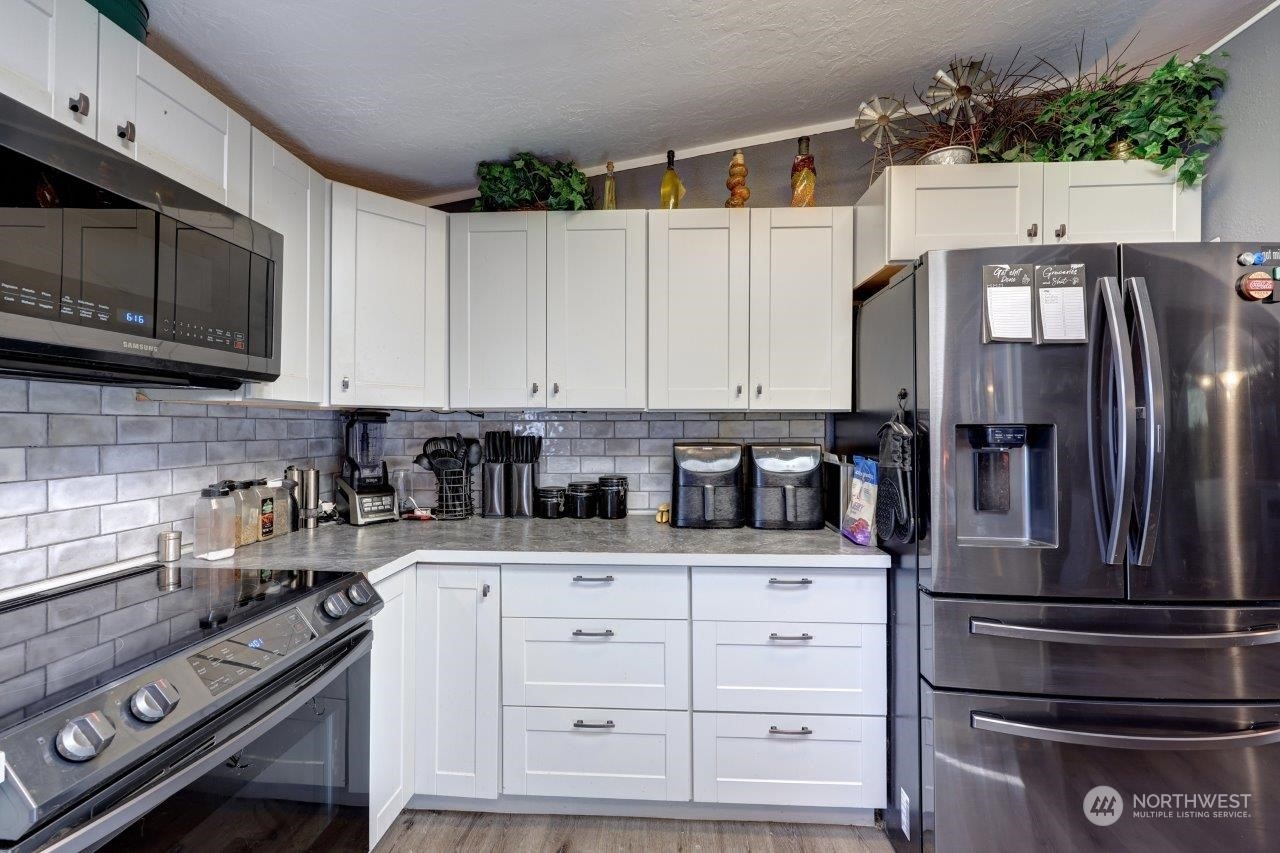 226 Stringtown Road Ilwaco, WA 98624 - Photo 12 of 40 a kitchen with granite countertop a sink stainless steel appliances and cabinets