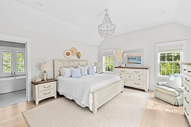 a spacious bedroom with a bed and a chandelier