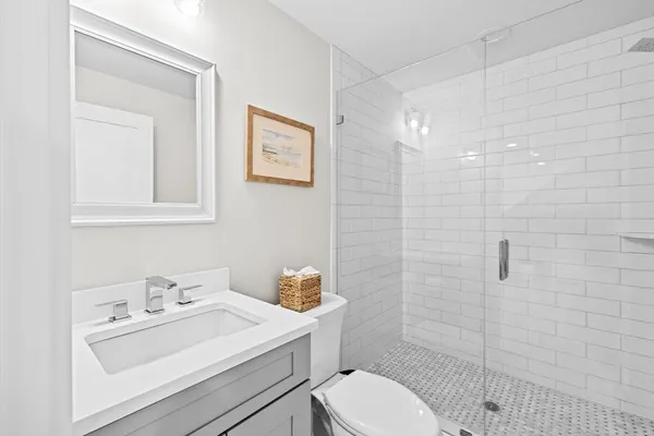 a bathroom with a sink a toilet and shower