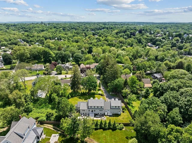 an aerial view of residential house with outdoor space and trees all around