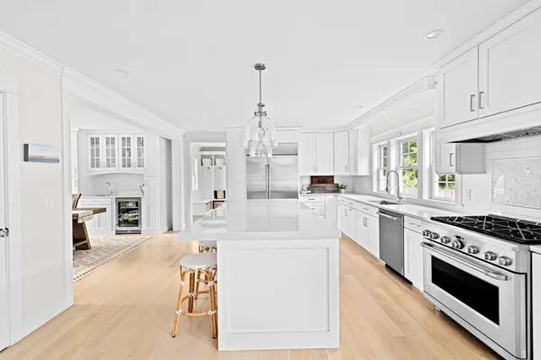 a large white kitchen with cabinets and a stove