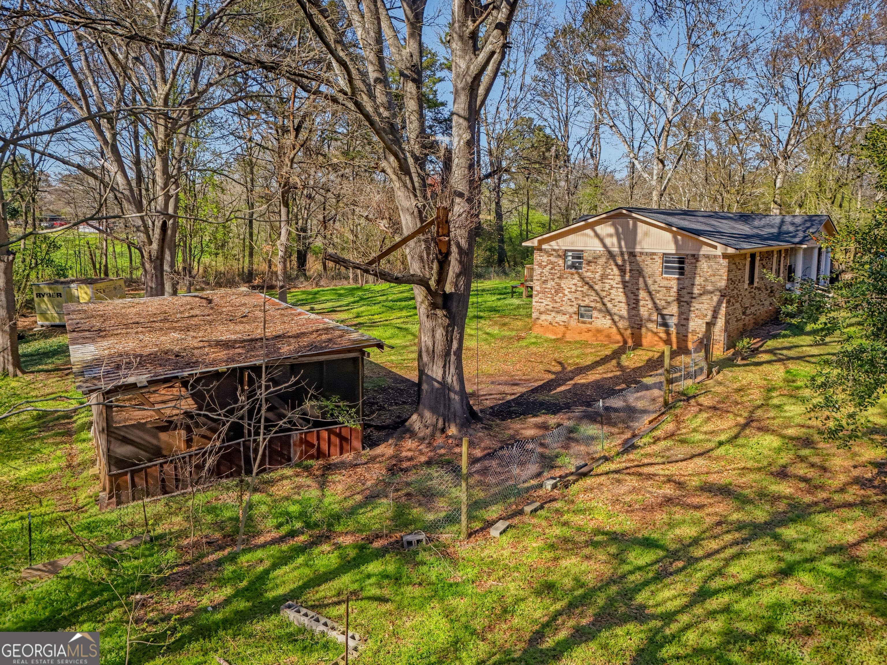 4124 Mangum Mill Road Gainesville, GA 30507 - Photo 43 of 48 a view of a patio with table and chairs under an umbrella with large trees