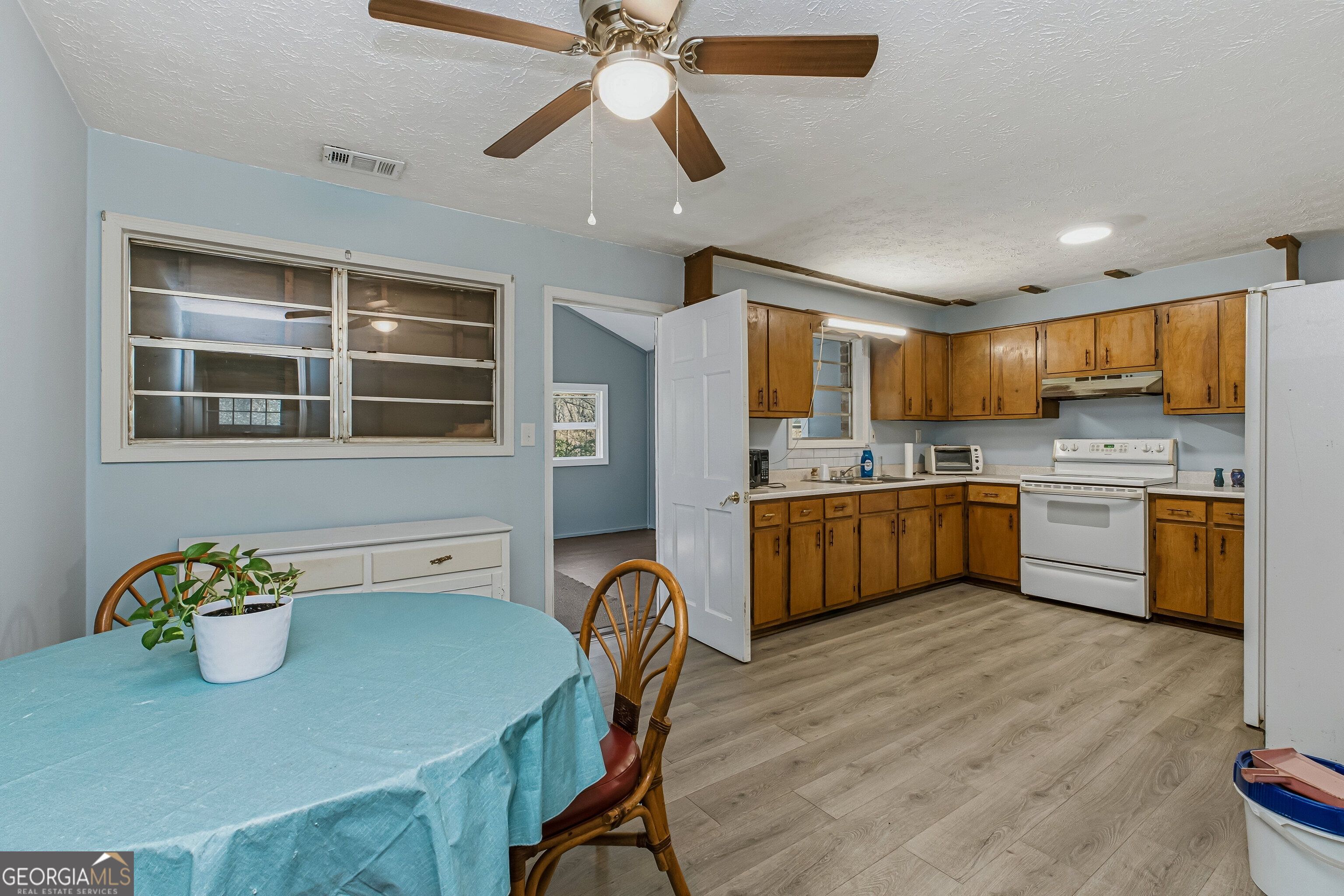 4124 Mangum Mill Road Gainesville, GA 30507 - Photo 7 of 48 a kitchen with a table chairs sink microwave and cabinets