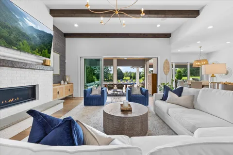 a living room with furniture a chandelier and a fireplace