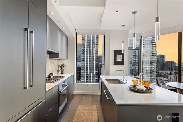 a kitchen with stainless steel appliances a sink a stove and a wooden floor