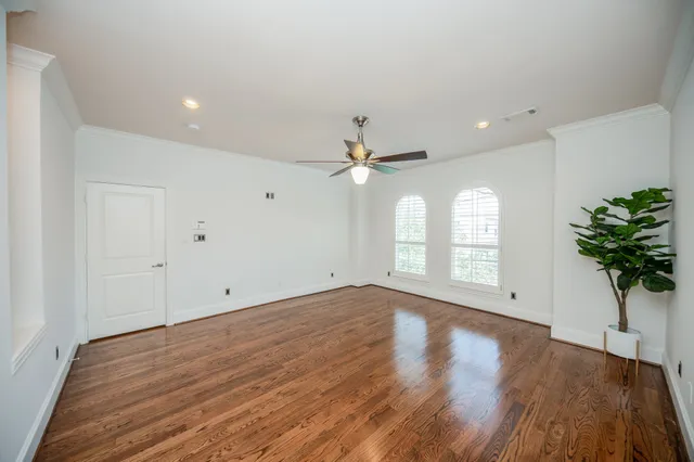 a view of empty room with window and wooden floor