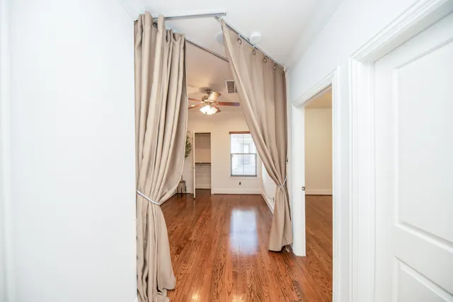 a view of a hallway with wooden floor and staircase