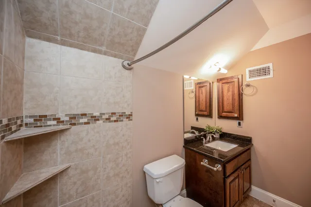 a bathroom with a granite countertop sink a toilet and mirror