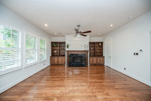 an empty room with wooden floor and fireplace