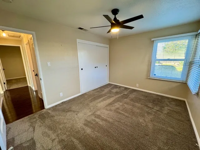 a view of a livingroom with a ceiling fan and window