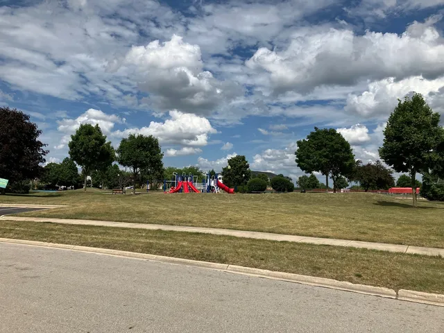a view of a playground ground and trees