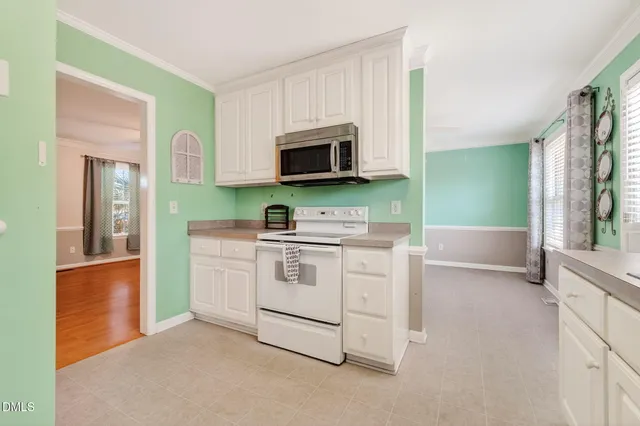 a kitchen with stainless steel appliances granite countertop a refrigerator a stove and a sink