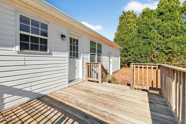 a front view of house with yard and trees in the background