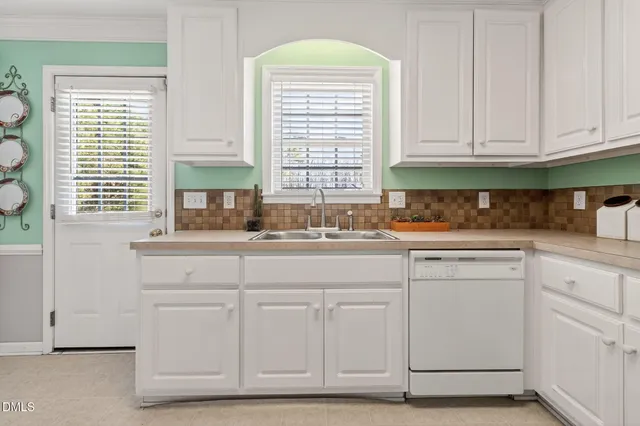 a kitchen with granite countertop white cabinets and refrigerator